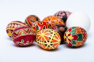 A collection of traditional Ukrainian Pysanka eggs with colorful wax-resist dyed patterns in red, yellow, and green.